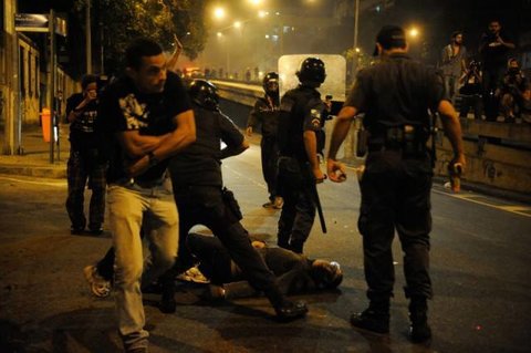 An image of a Brazilian man suspected of being an undercover police officer taking off his T-shirt after assisting in the arrest of a protester in Rio on Monday.